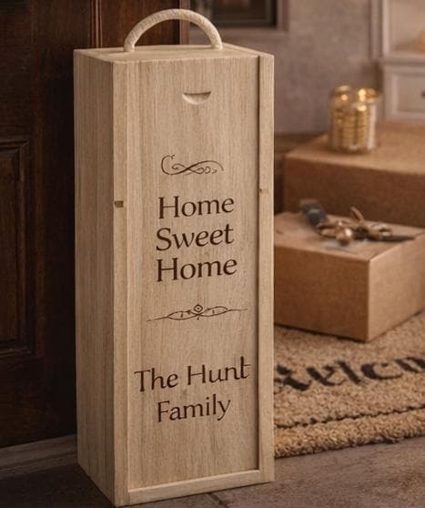 Wooden wine box with 'Home Sweet Home' and 'The Hunt Family' engraving on a carpeted floor.